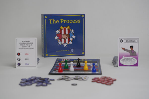 A complete set of The Process Game with all its components (political and trivia cards, gamr board, game pieces, and tokens) laid out.